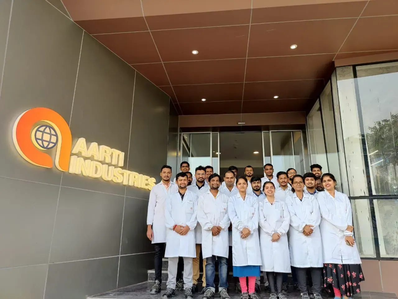 Diverse team of Aarti Industries employees posing together in professional corporate setting